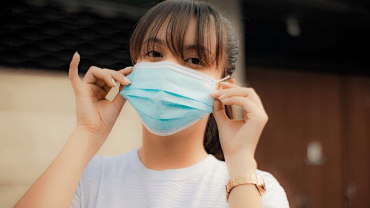 Person wearing a blue medical mask 