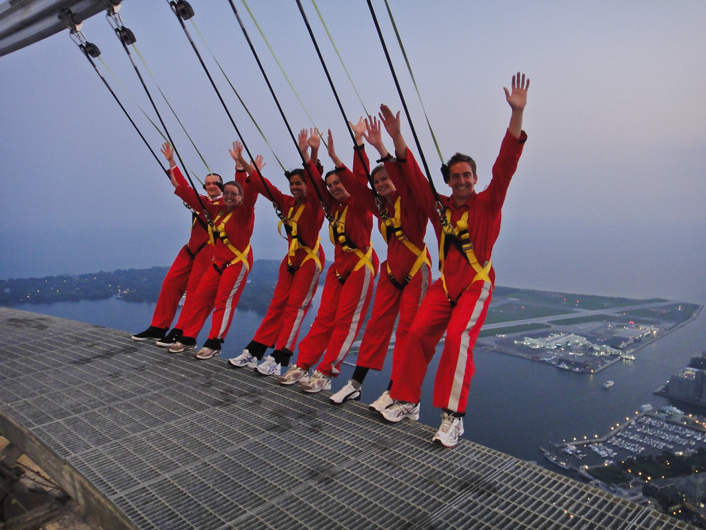 Group of 6 people walking on the edge of the CN tower. Photo by wschraml on Flicker.com. 